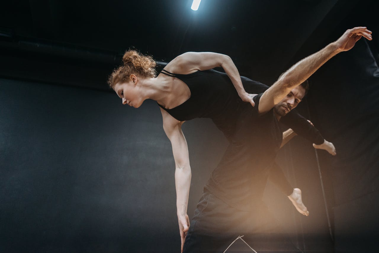 Two dancers in a captivating lift showcasing grace and strength indoors.